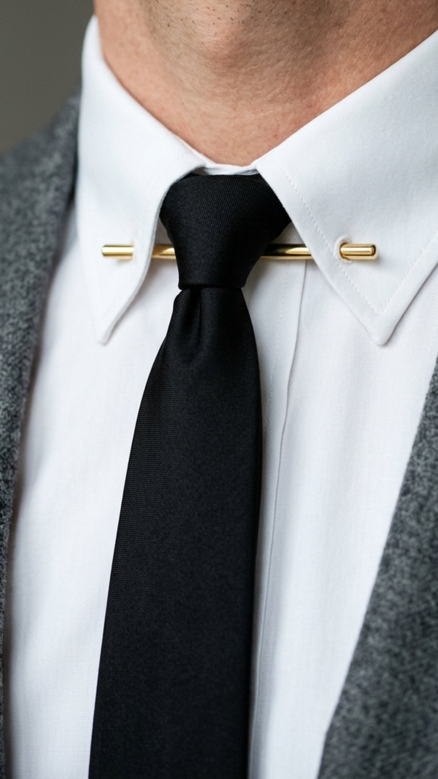A collar pin joining two collar points and lifting the tie knot