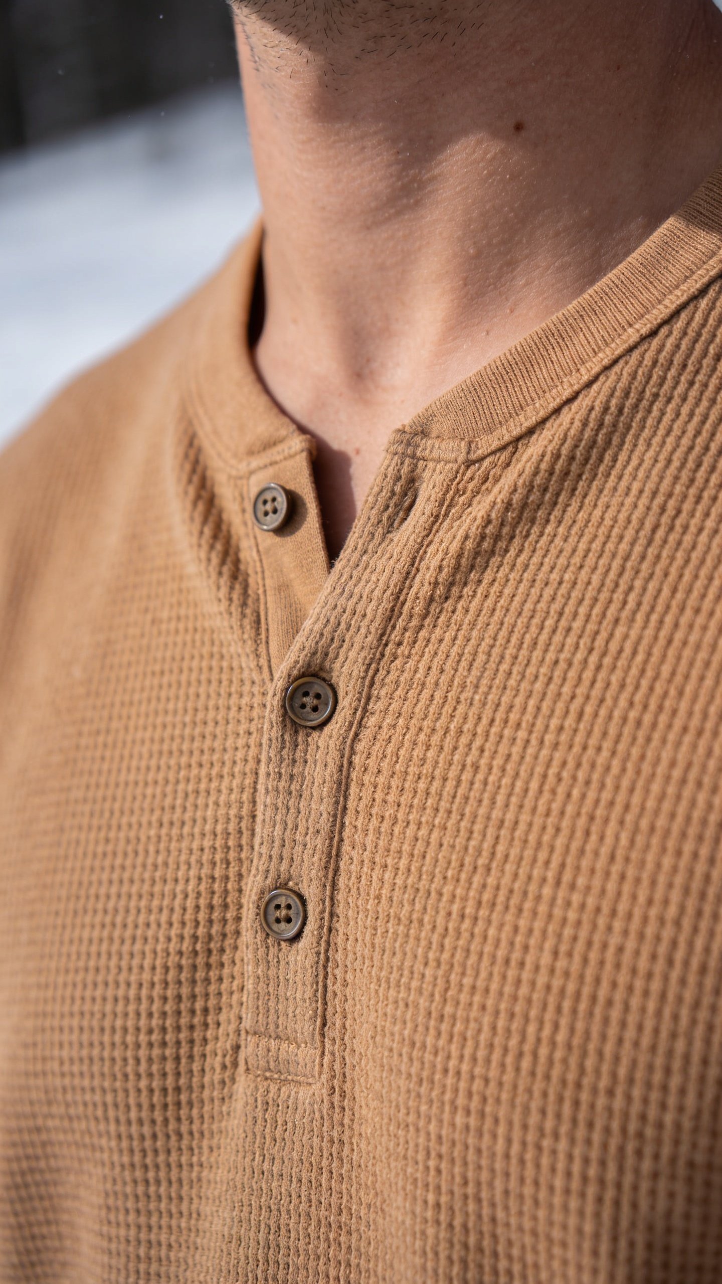 A waffle knit henley with the placket open at the throat