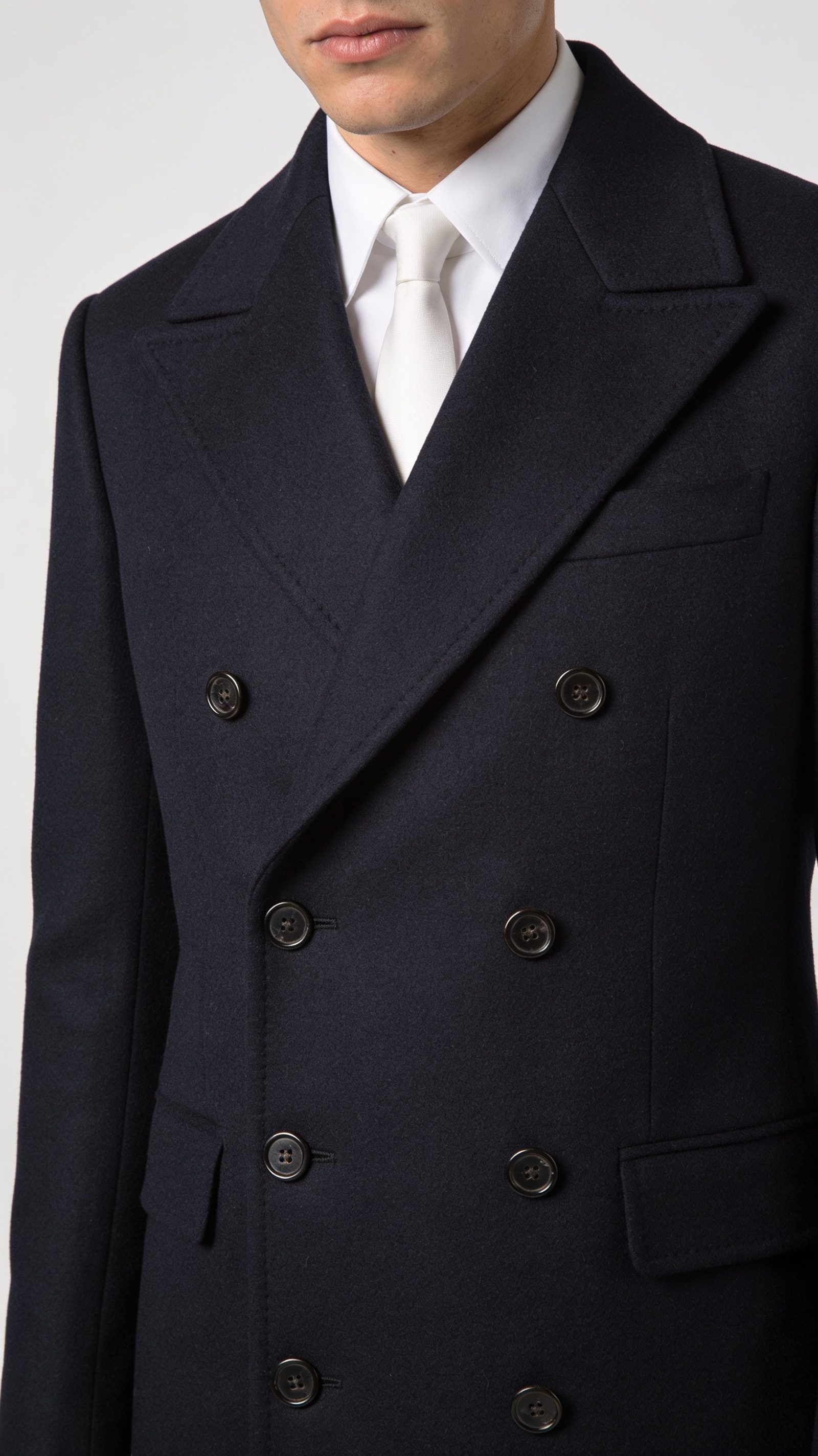 A navy double-breasted jacket buttoned with peak lapels
