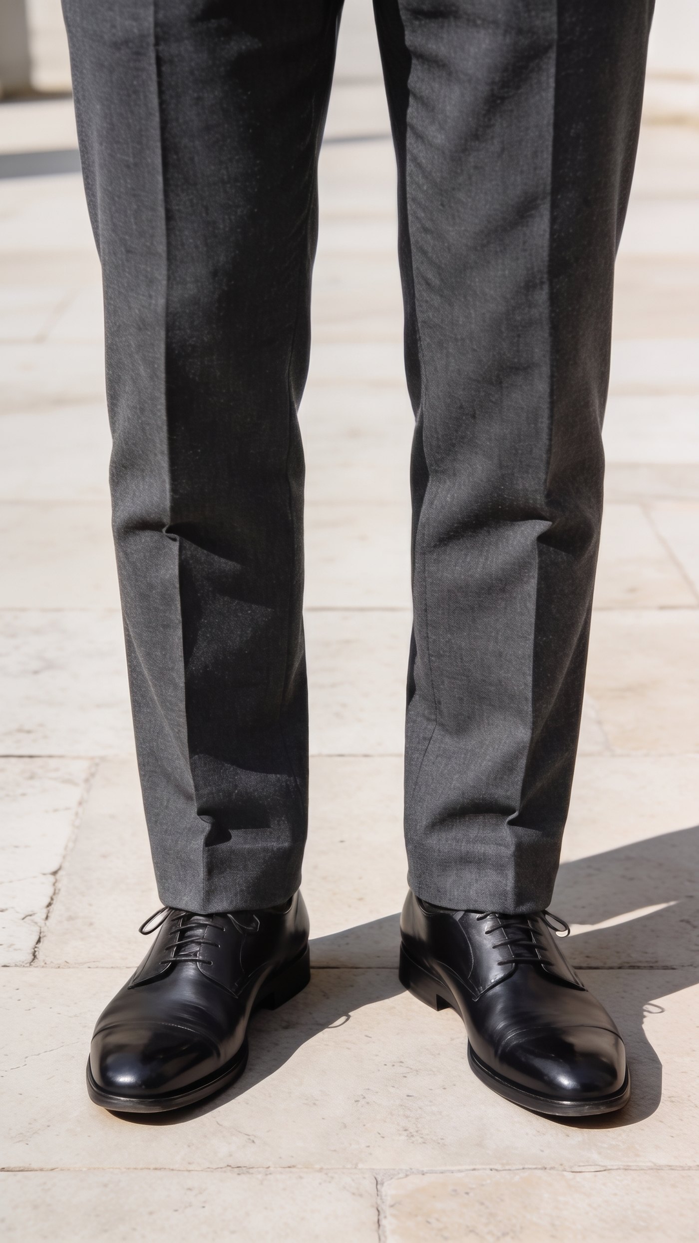 Trousers ending in a single soft fold on the top of the shoe