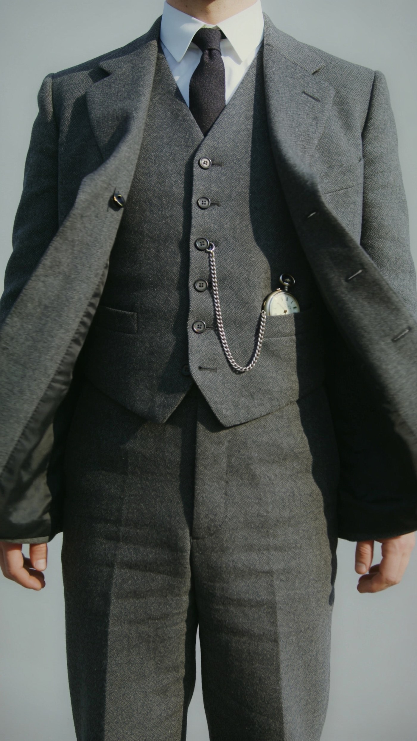 A fitted wool waistcoat buttoned under an open suit jacket